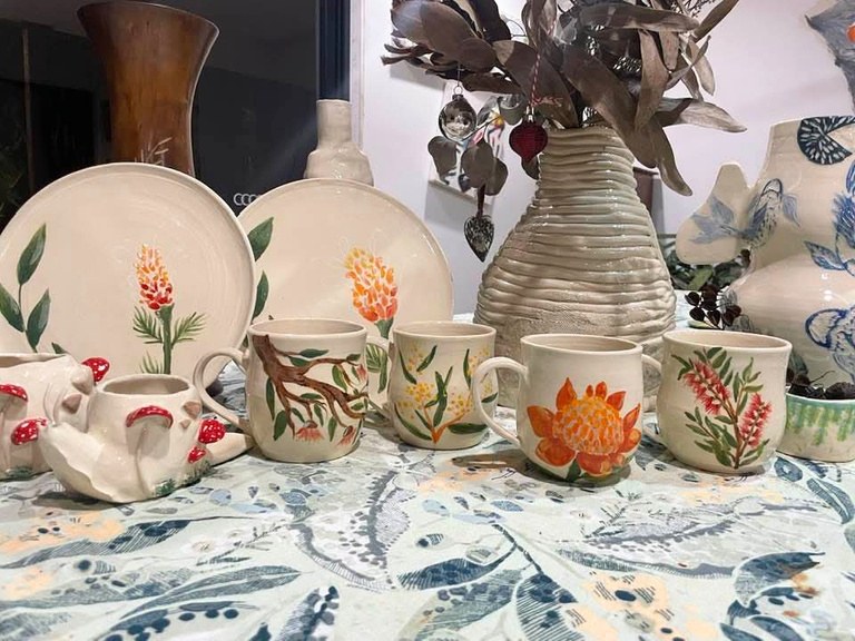 Hand-painted botanical plates, mugs and a vase made in the studio